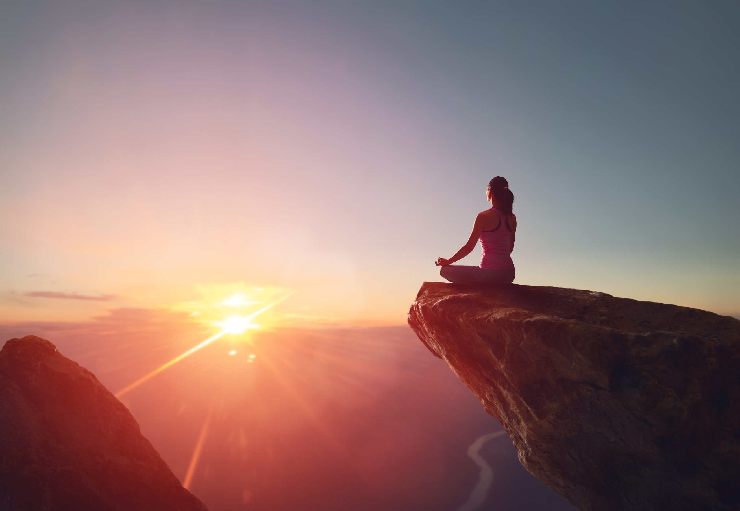 Woman meditating yoga alone at sunrise mountains